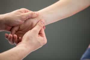 Woman receiving myofascial therapy for hand pain.